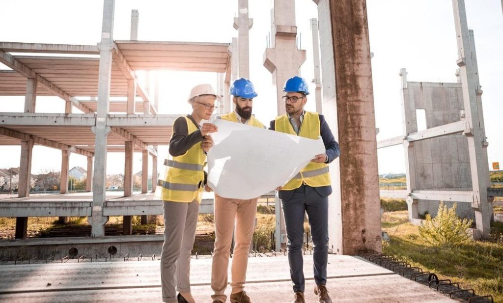 Overzicht van essentiële efficiënte bouwapparatuur: graafmachine, hijskraan, betonmixer en steiger op bouwplaats