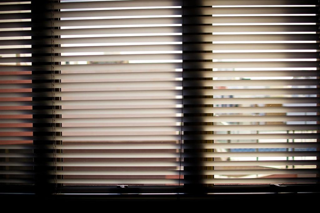 Elegante witte houten jaloezieën in een moderne woonkamer met natuurlijk licht